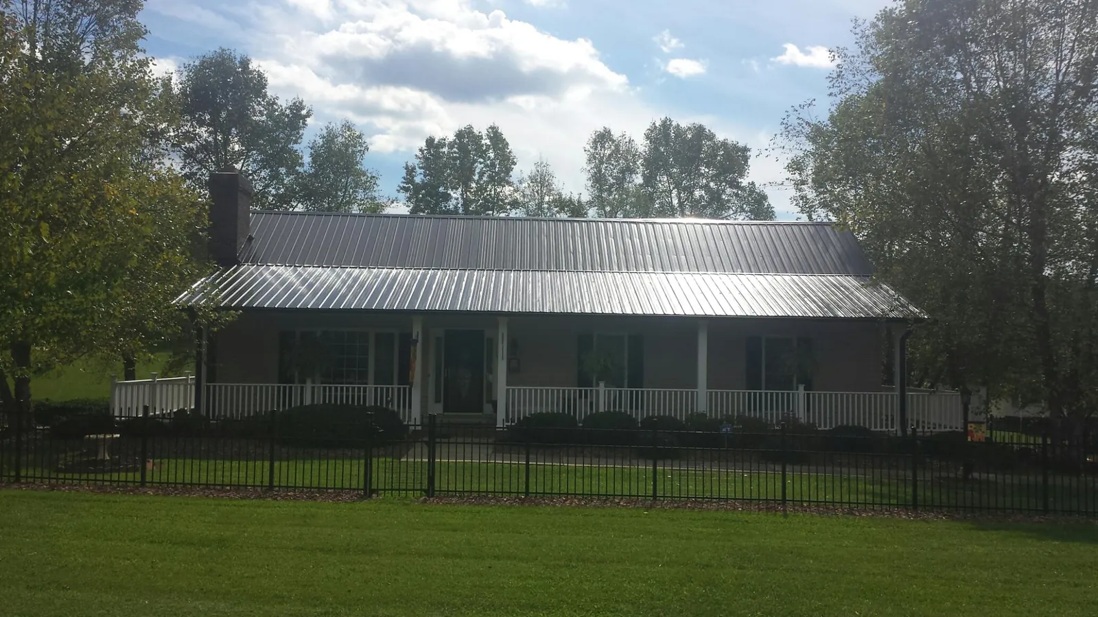 Gray metal roof on a brick ranch with a full width front porch — Gutter Guard Installation work by our crew in Avondale Estates