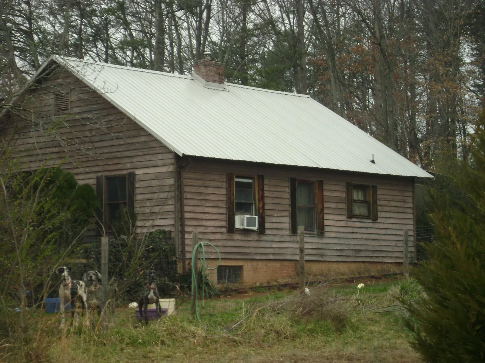 White metal roof on an old wood sided farmhouse, from a Metal Roof Installation job in Avondale Estates